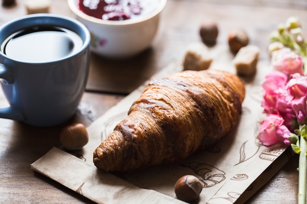 Kaffeecroissant auf altem Holztisch