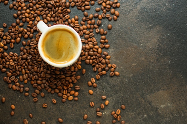 Kaffeegetränk in der weißen Schale und streuen Kaffeebohnen auf dem Tisch