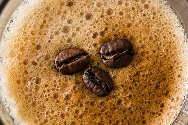 Kaffeeglas und Kaffeekorn auf Holztisch schließen oben