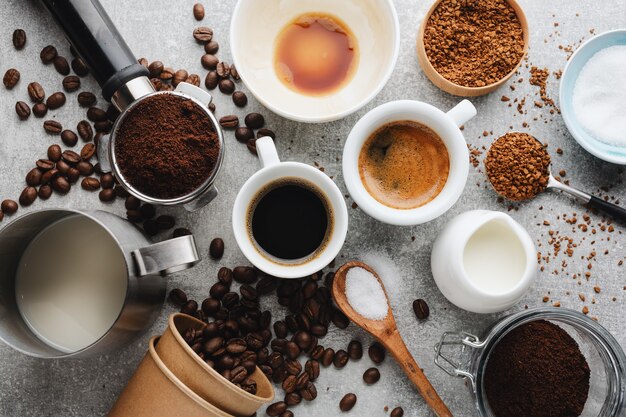 Kaffeekonzept mit verschiedenen Kaffeesorten und Requisiten für die Kaffeezubereitung auf grauem Hintergrund. Von oben betrachten.