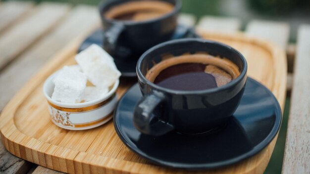 Kaffeekuppen und -schüsseln sitzen mit einer Tasse Kaffee auf einem Tisch