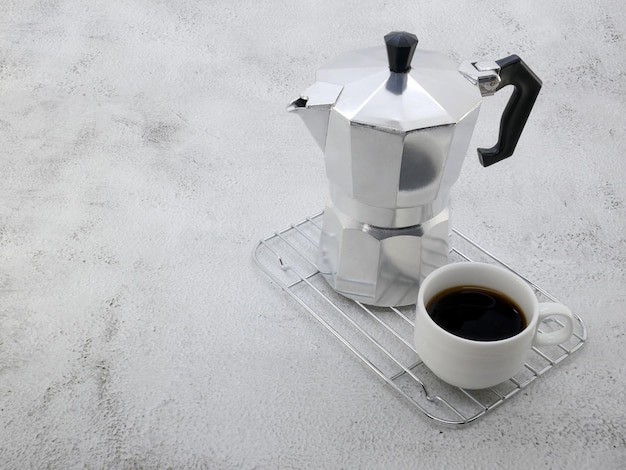 Kaffeemaschine moka Pot und eine Tasse auf Steinhintergrund