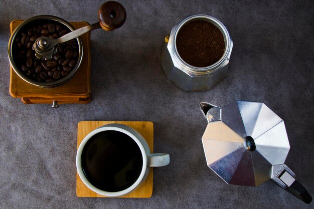 Kaffeemaschinen und Kaffeebohnen auf dem grauen Hintergrund