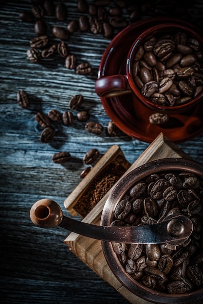 Kaffeemühle Körner Tasse Untertasse auf Holzbrett