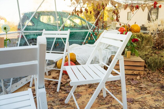 Kaffeepause. Café im Herbst. Weiße Holzstühle in einem Café. Goldener Herbst.