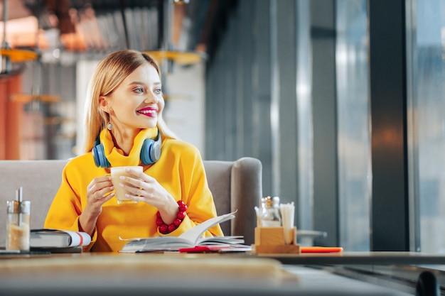 Kaffeepause. Schöne junge blonde Geschäftsfrau, die ihre Kaffeepause genießt