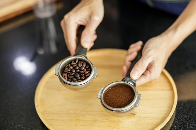 Kaffeesatz im Siebträger für Espresso in der Hand Barista