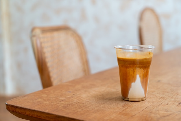 Kaffeespezialitätenmenü namens "Dirty Coffee". Kalte Milch unten mit heißem Espresso oben im Café und Restaurant des Coffeeshops