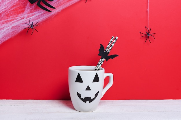 Kaffeetasse als Kürbislaterne Kürbis auf Holztisch. Halloween-Konzept