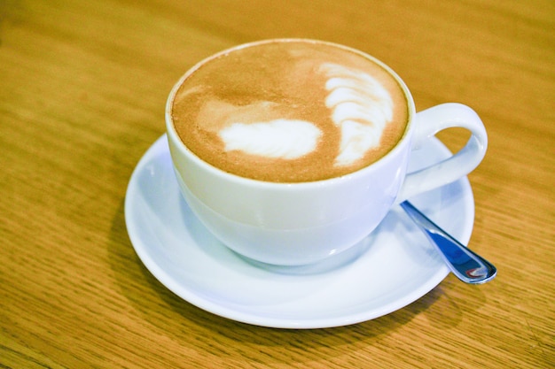 Kaffeetasse auf einem Holztisch mit Löffel
