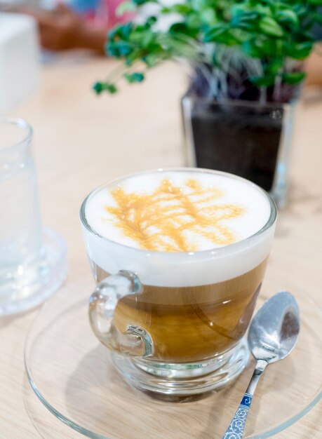 Kaffeetasse auf Holztisch auf braunem Hintergrund