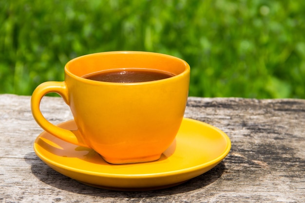 Kaffeetasse auf rustikalem Holztisch im Freien