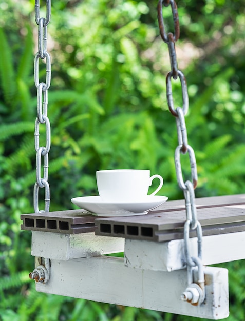 Kaffeetasse auf Sitz durch Ketten aufgehängt