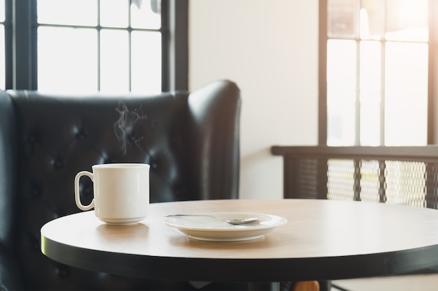 Kaffeetasse auf Tisch Cafe Shop in der Nähe von Fenster gesetzt Interior Blur Menschen Hintergrund