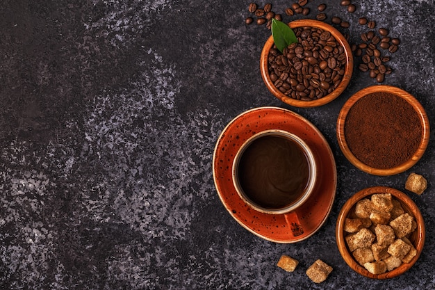 Kaffeetasse, Bohnen, gemahlenes Pulver und Zucker.