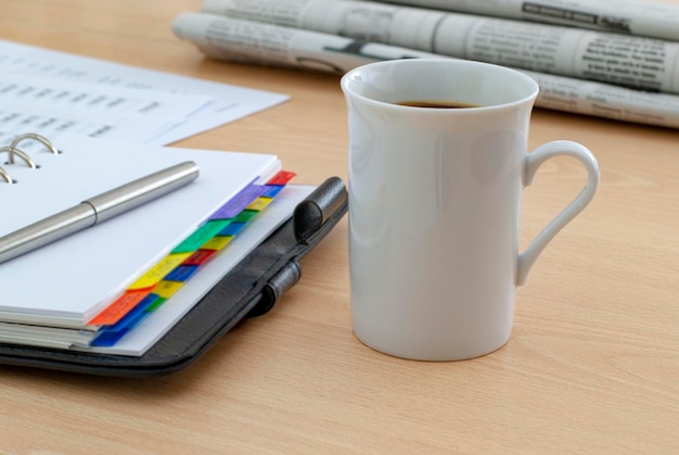 Kaffeetasse, die auf dem Schreibtisch steht