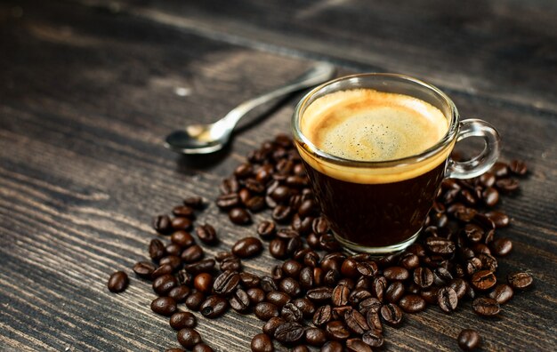 Kaffeetasse Espresso und Bohnen auf einem Holztisch. frühstückskonzept,