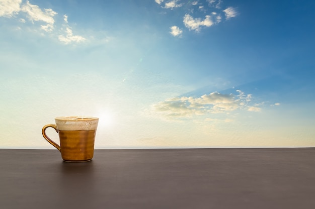 Kaffeetasse ist auf dem Tisch mit Blick auf den Himmel und die Wolken