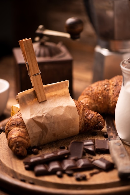 Kaffeetasse mit Croissant und frischem Kaffee auf braunem Hintergrund