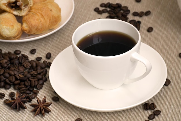 Foto kaffeetasse mit croissant zum frühstück