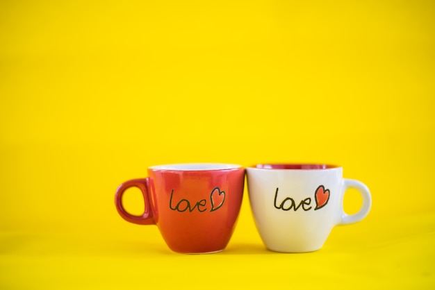 Kaffeetasse mit dem Wort "Liebe" auf gelbem Hintergrund