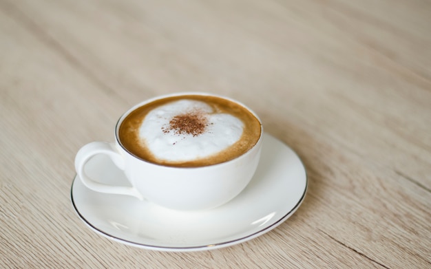 Kaffeetasse mit Herzen auf alter Tabelle