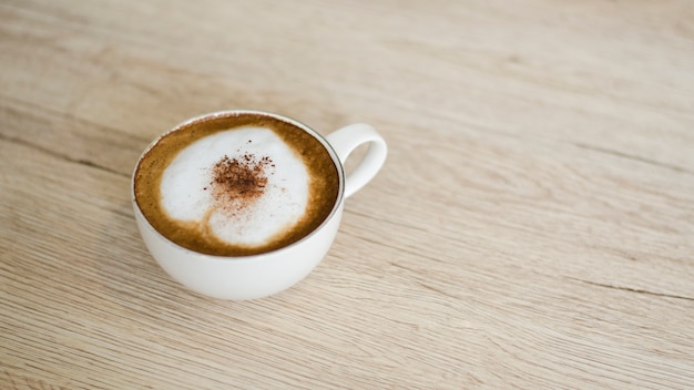 Kaffeetasse mit Herzen auf alter Tabelle