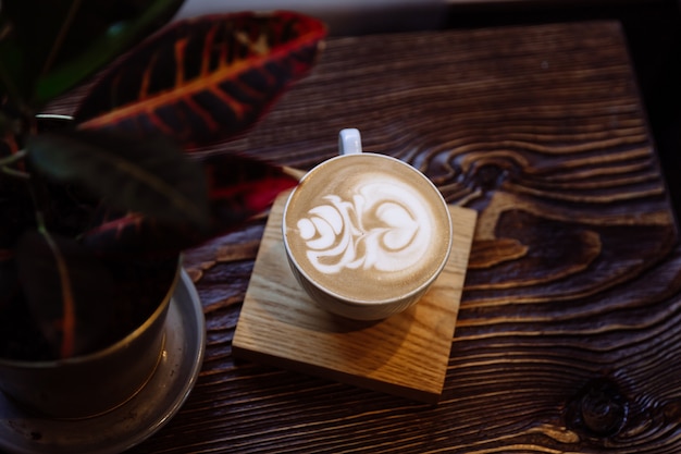 Kaffeetasse mit Latte Art neben Innenanlage