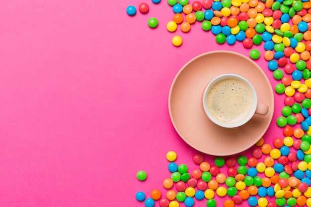 Kaffeetasse mit Pralinen und farbigen Süßigkeiten Draufsicht auf Tischhintergrund mit Kopierraum