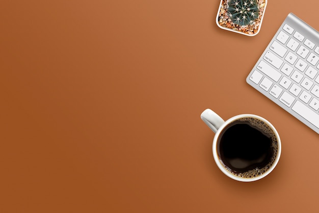 Kaffeetasse mit Tastatur auf braunem Hintergrund