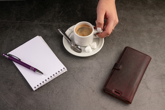 Kaffeetasse mit Telefon und Notizbuch