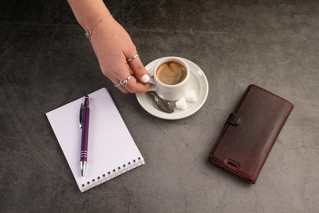 Kaffeetasse mit Telefon und Notizbuch