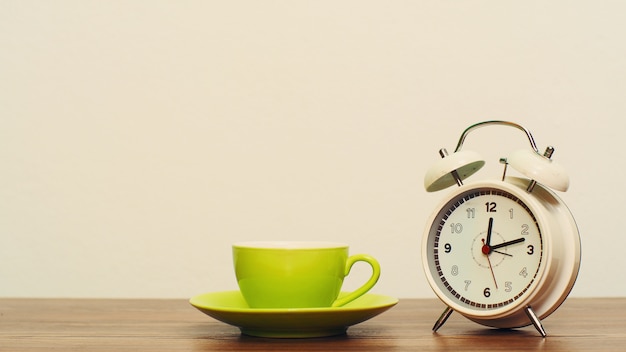 Kaffeetasse mit weißer Uhr auf Holz, Kaffeepause