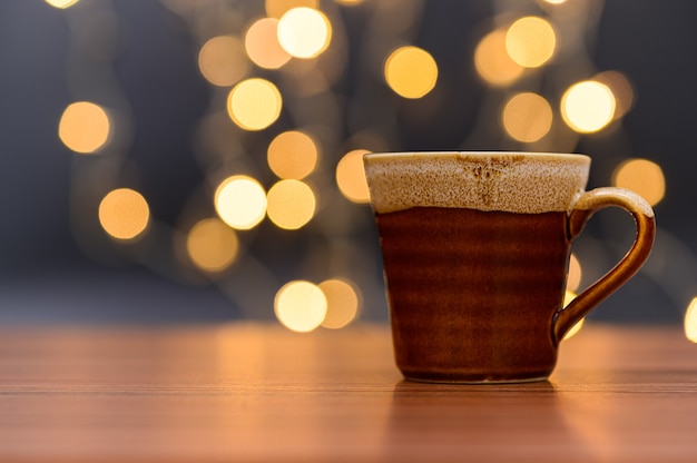 Kaffeetasse steht auf dem Schreibtisch Orange Bokeh Bodenszene