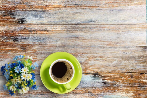 Kaffeetasse und Blume auf altem Holztischhintergrund