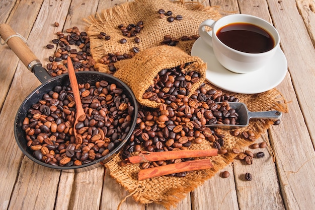 Kaffeetasse und Bohnen auf altem Holztisch