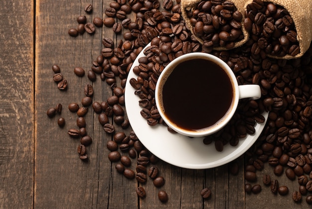 Kaffeetasse und Bohnen auf rustikalem Hintergrund. Espresso.