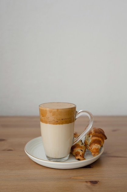 Kaffeetasse und Croissant auf Holztisch mit Kopierraum