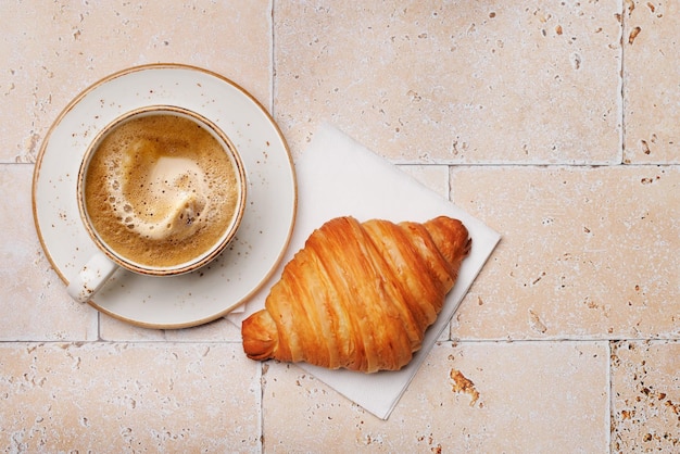 Kaffeetasse und Croissant