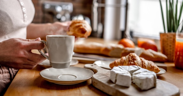 Kaffeetasse und Croissants am Küchentisch