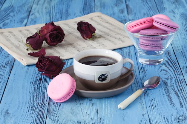 Kaffeetasse und getrocknete rote Rose auf Holztisch