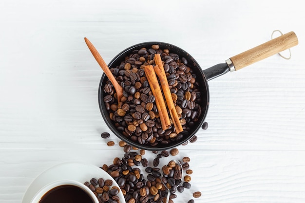 Kaffeetasse und Kaffeebohne auf weißem Holztisch