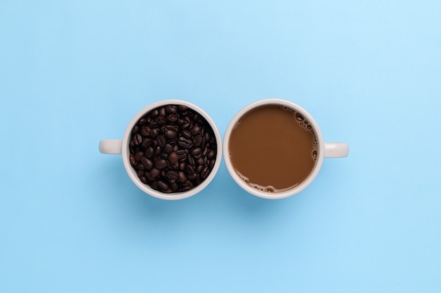 Kaffeetasse und Kaffeebohnen auf blauem Hintergrund