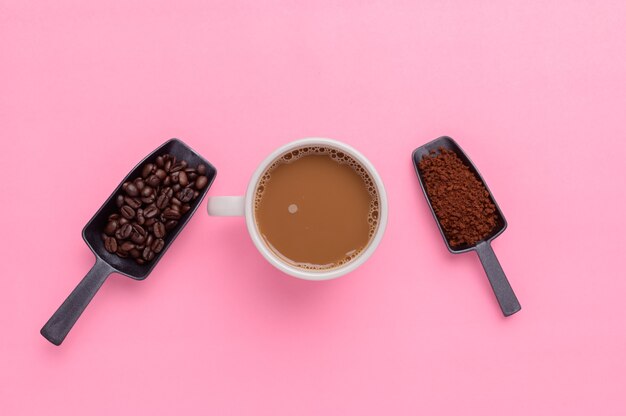 Kaffeetasse und Kaffeebohnen auf rosa Hintergrund