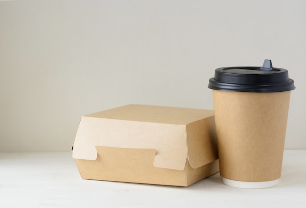 Kaffeetasse und Lebensmittelbox aus Papier auf dem weißen Tisch basteln