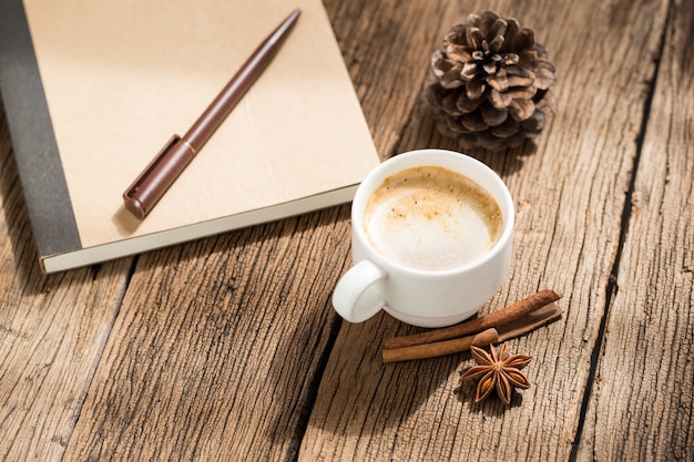 Kaffeetasse und Zimtstangen auf alten Holztisch