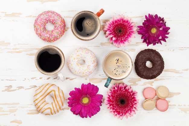 Kaffeetassen, Donuts und Gerberablüten