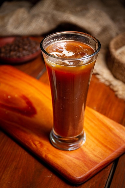 Kaffeetassen Milchbohnen und gemahlener Kaffee im Glas auf Holzhintergrund Hochwertiges Foto