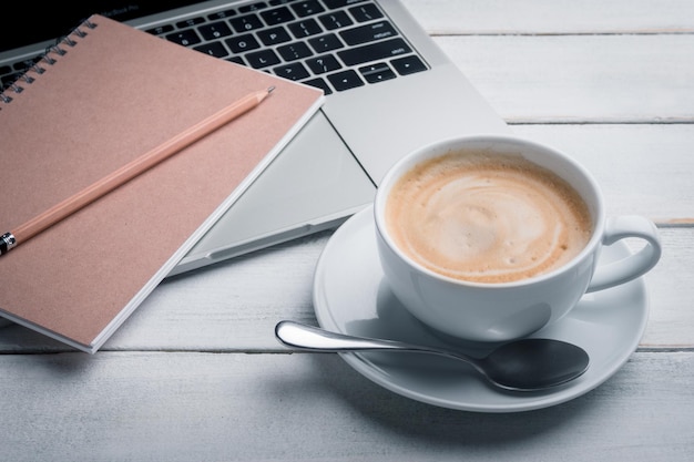 Kaffeetassen, Notizbücher, Zeitungen und Laptops werden auf den Tisch gestellt. Morgennachrichten, Morgen