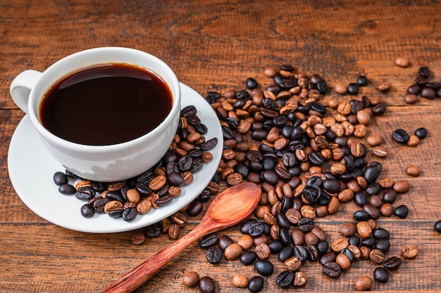 Kaffeetassen und Kaffeebohnen auf einem Holztisch